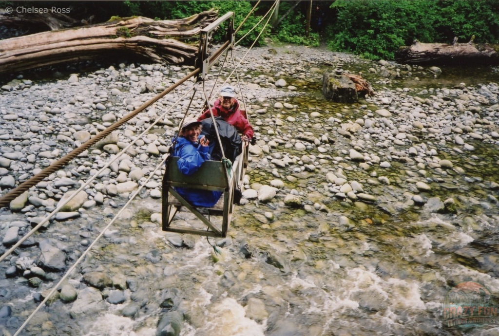 lady and girl in cable car crossing a creek
