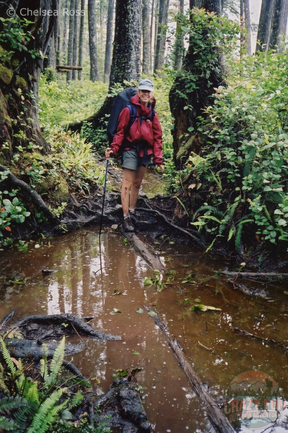 Standing on a slippery log, getting ready to cross a puddle of mud and slippery roots. Be careful with these West Coast Trail trips.