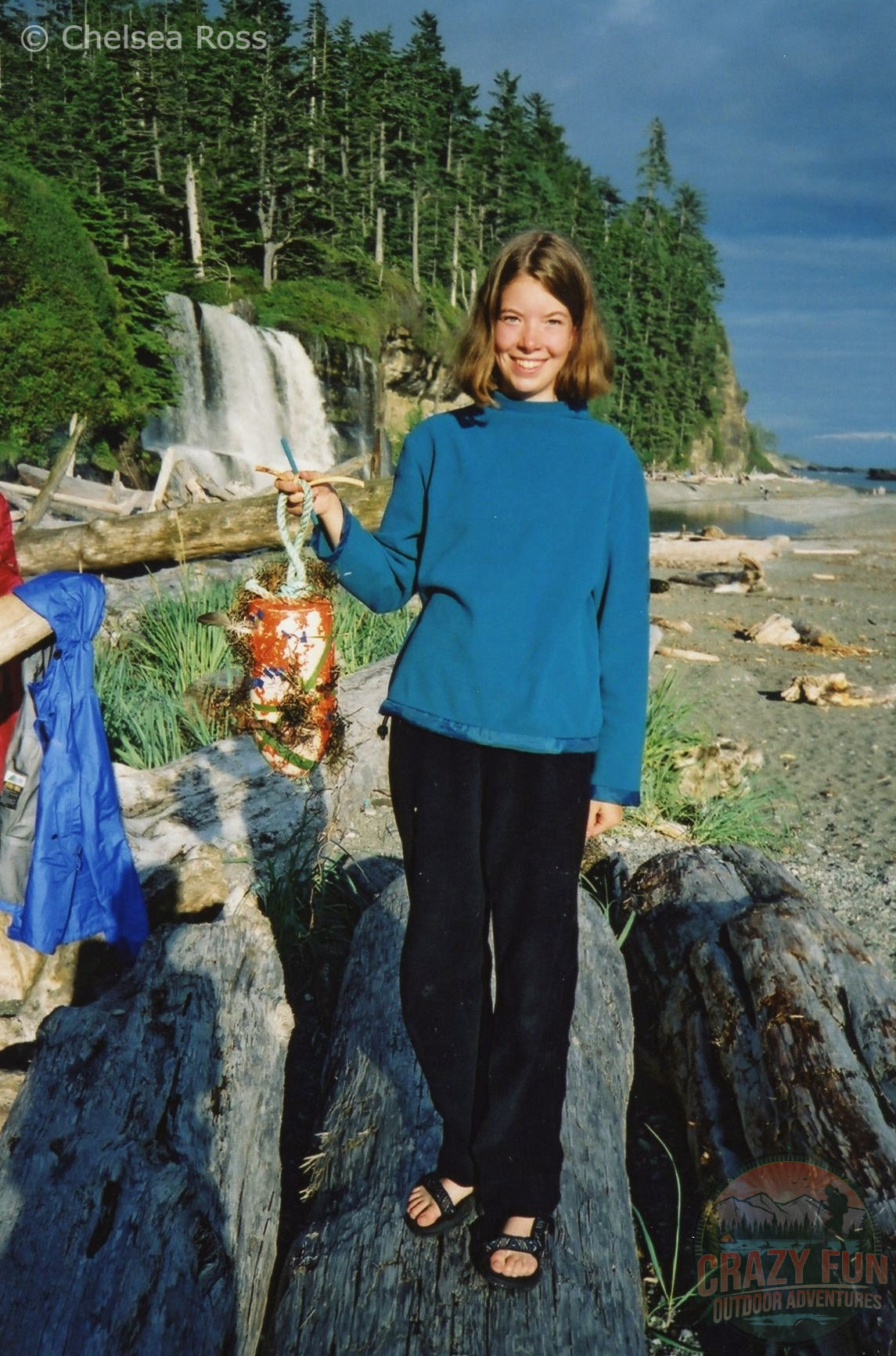 Girl standing in front of falls with decorated buoy
