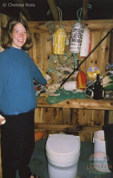 Girl Inside an outhouse with yellow and white buoys.