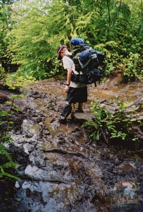 Boy stuck in knee deep mud in the middle of the trail.