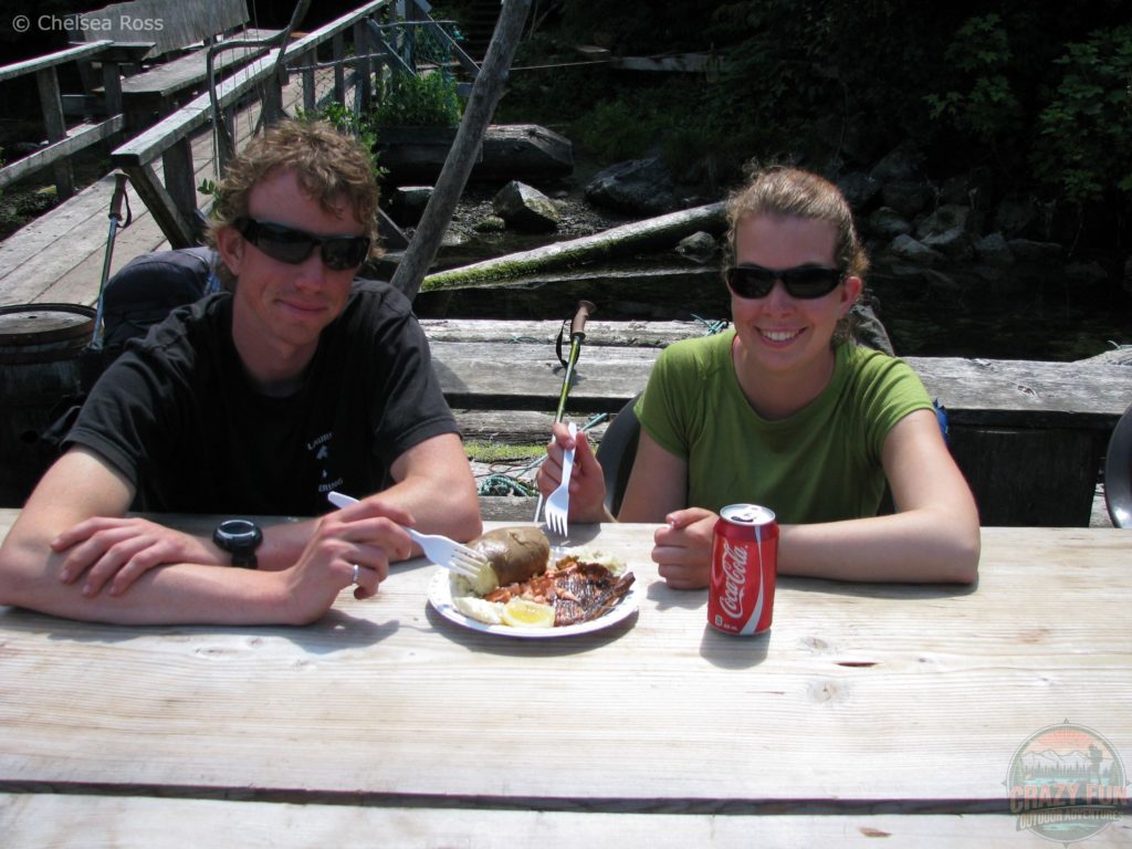 West Coast Trail tips: my brother and I eating delicious salmon at a picnic table and drinking coke. So worth it!