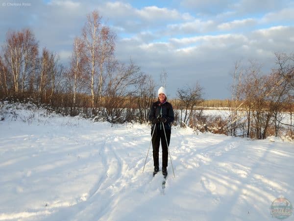 Lady standing in skis in the snow. Love cross-country skiing like her.