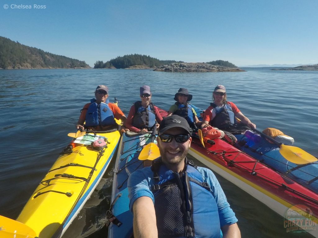 A family group shot sitting in our kayaks in the ocean while kayaking in Desolation Sound.