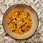 Texas Cajun Mix containing almonds, pumpkin seeds, corn, peanuts and sesame seeds in a tan bowl on a countertop are easy snack ideas for kayaking.