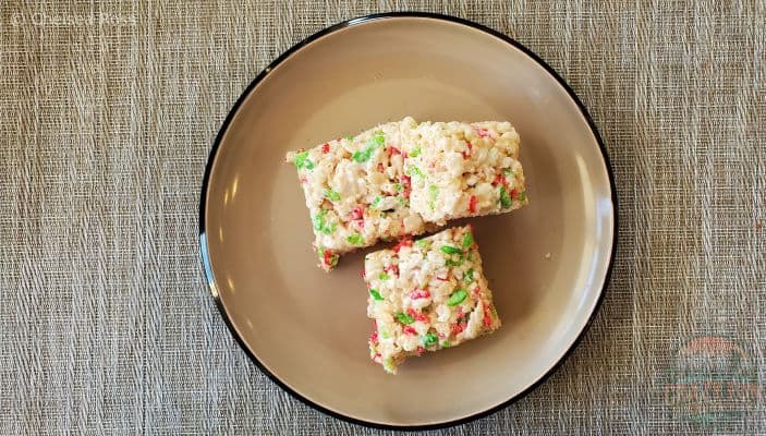 Three Rice Krispie Christmas Dessert squares sit on a plate.  