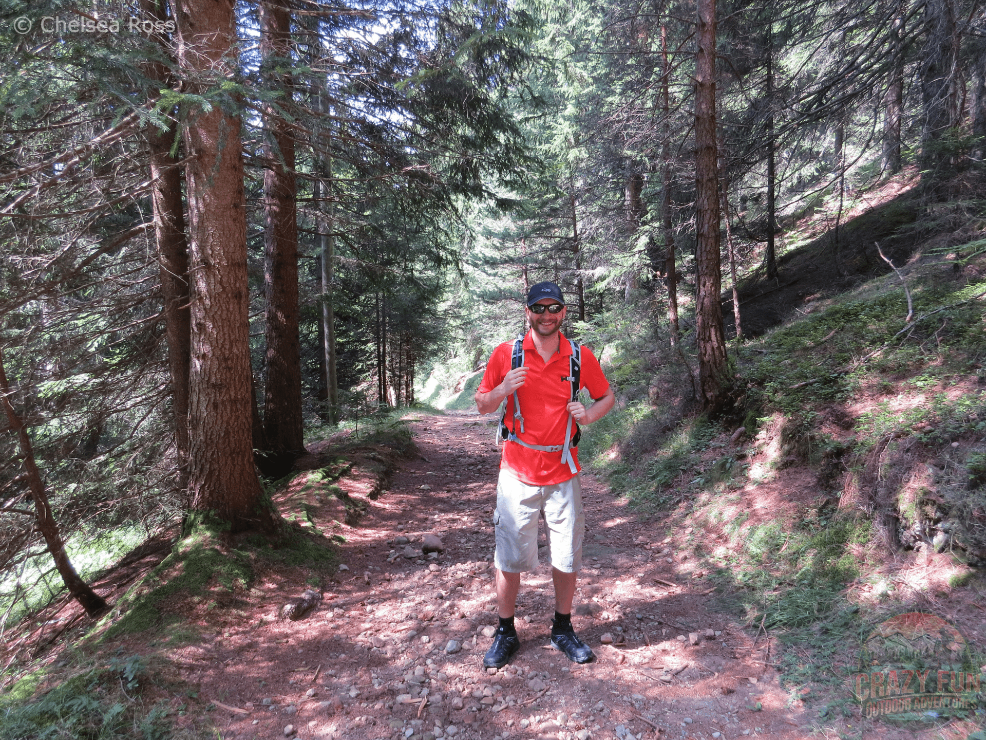 Kris standing in the middle of the trail on our unforgettable hiking holiday in Bolzano. There are trees surrounding him on both sides.