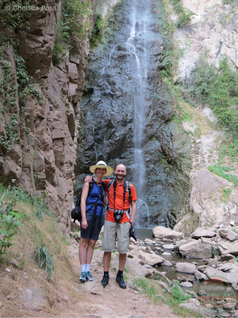 We are standing in front of the Vilpiano Waterfall. I'm wearing my blue tank top and Kris is wearing his orange t-shirt on our unforgettable Hiking Holiday in Bolzano.