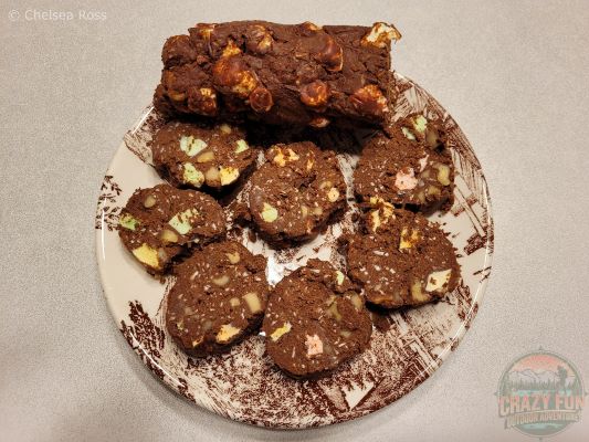 Marshmallow Yule Log made from marshmallows, coconut, walnuts and chocolate sit in a plate, as well as cut up round pieces to see what the inside looks like.  They are sixth on the Top 8 Christmas Desserts to make.