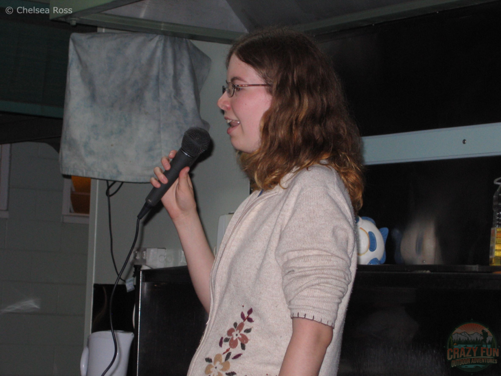 Date Ideas for Valentine's Day : Karaoke Sing Off! Side picture of me singing karaoke in Australia. Hair shoulder length, beige top while holding a microphone in my right hand. 