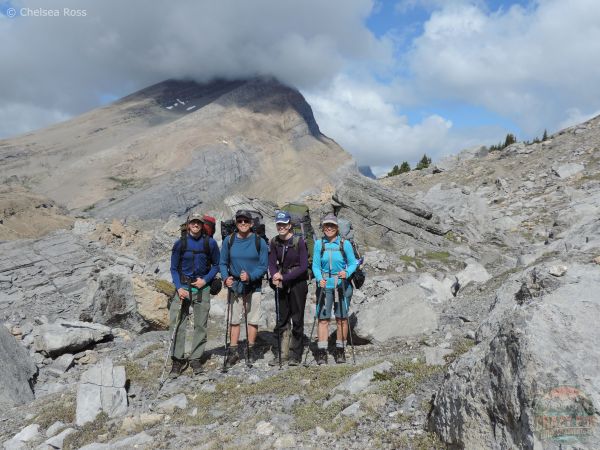 A family picture with rocks and mountains behind us as we start descending.