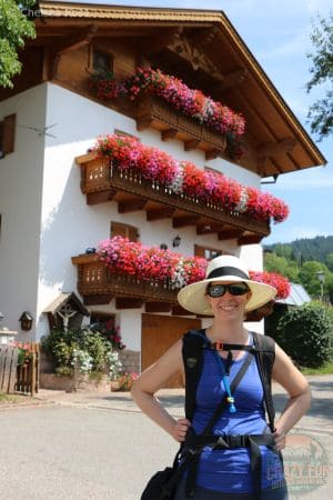 Red, purple and white flowers in full bloom hanging over the edges of balconies, in a quaint Italian and German village on our unforgettable hiking holiday in Bolzano.