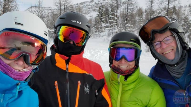 Group selfie of 4 adults on the ski hill.