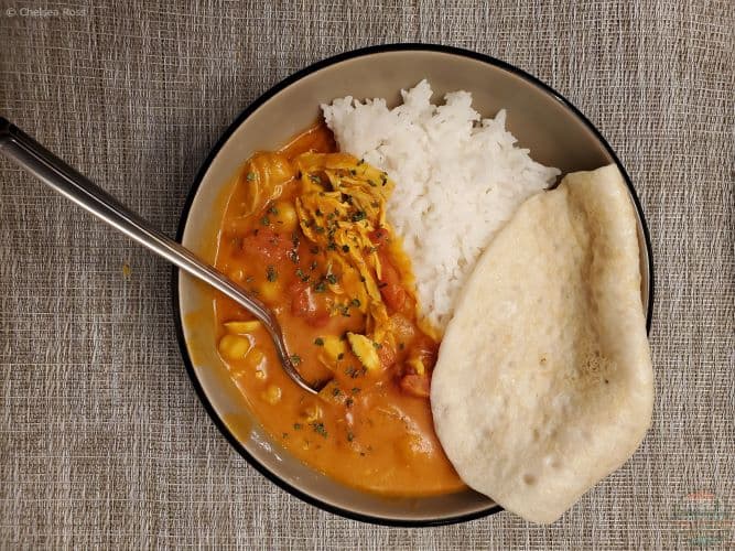 Butter Chicken in a bowl with rice and pita.