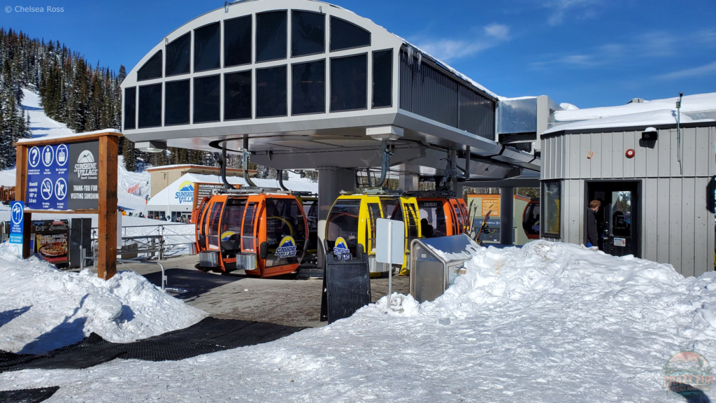 The gondola at the base of the Sunshine Ski hill. It shows the gondola compartments circling to head back down to the bottom. 