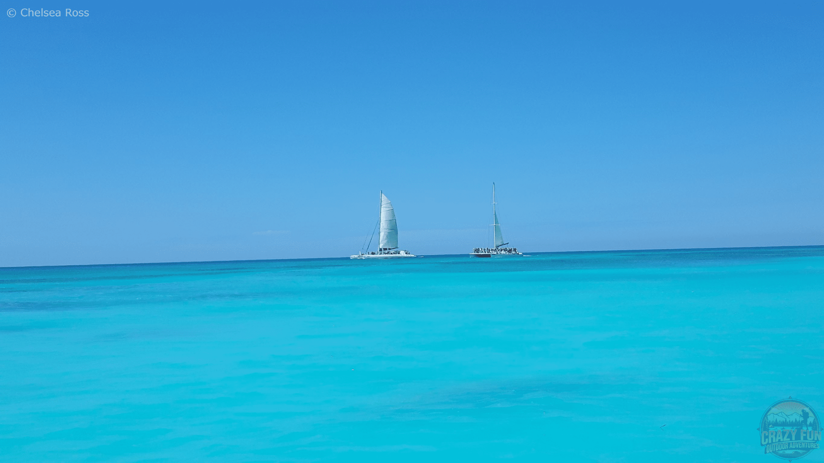 The blue turquoise ocean with two other catamarans in the distance.