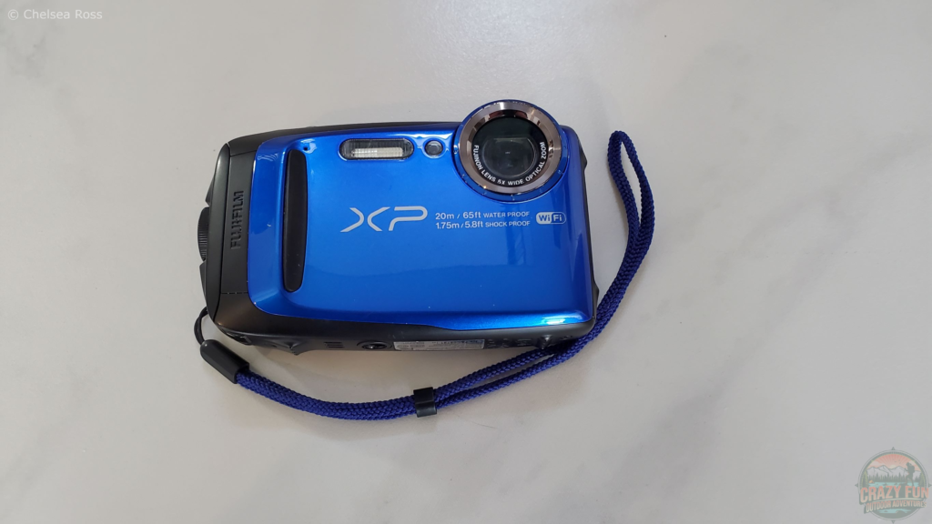 A picture of my blue underwater camera. It's an XP Fujifilm camera taken on a white and grey tile. 