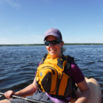 I'm wearing my MEC Fulcrum Guide PFD while kayaking. It's bright yellow on me while the lake is surrounding me.