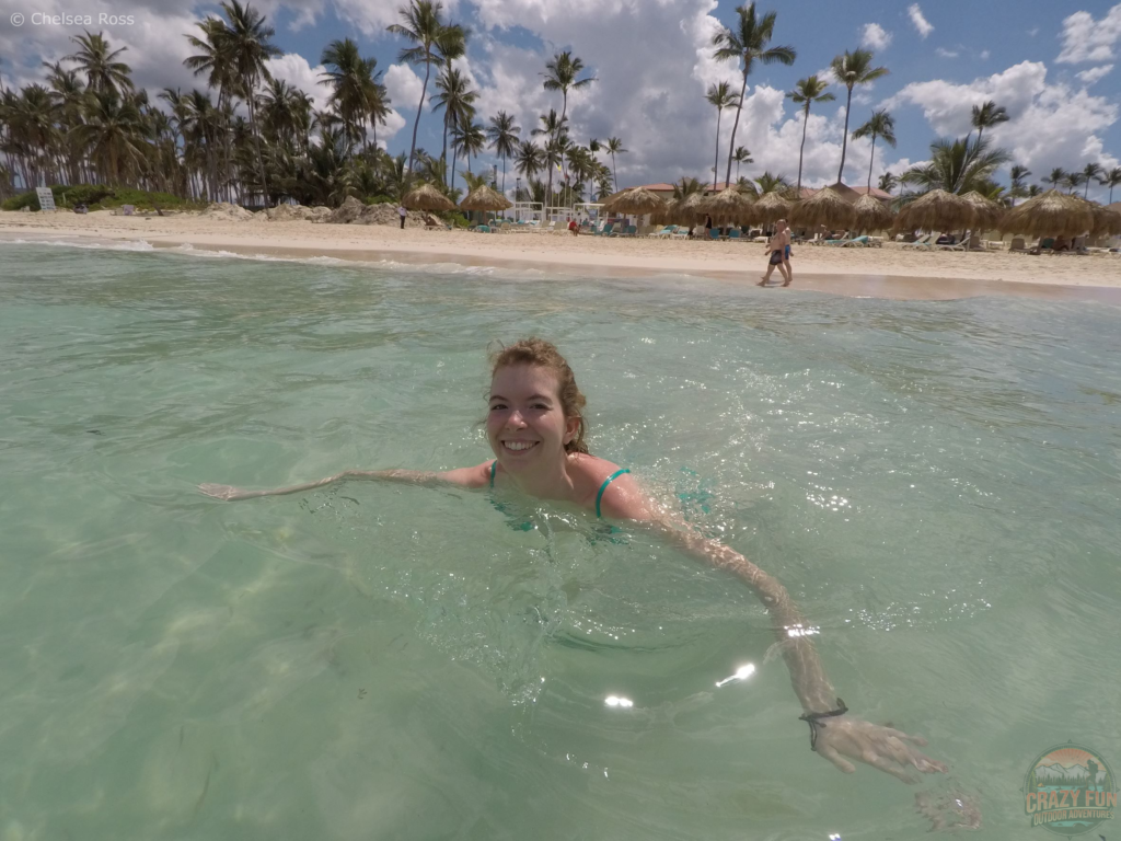 Swimming in the clear ocean. Palm trees are in the background.