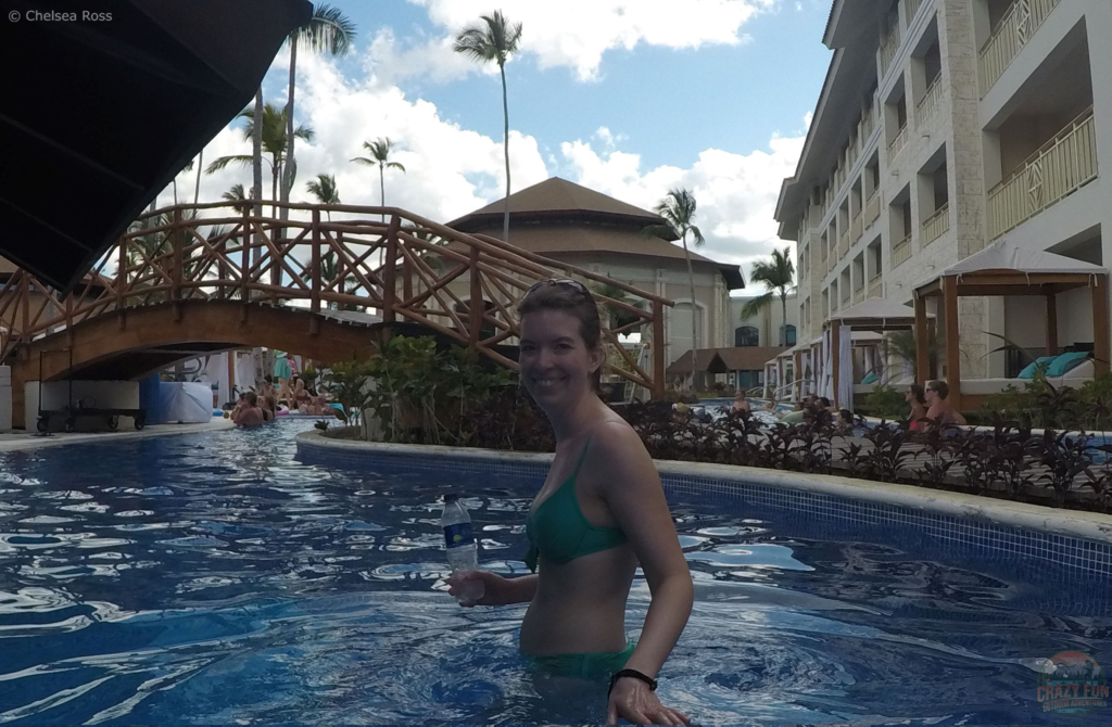 Stay hydrated to treat a sunburn. I'm swimming in a pool while holding a water bottle. 