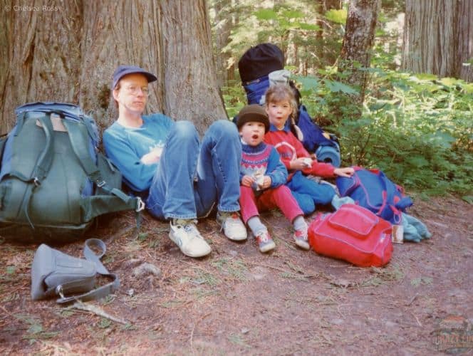 My man and two kids resting against a tree backpacking to Kinney Lake.