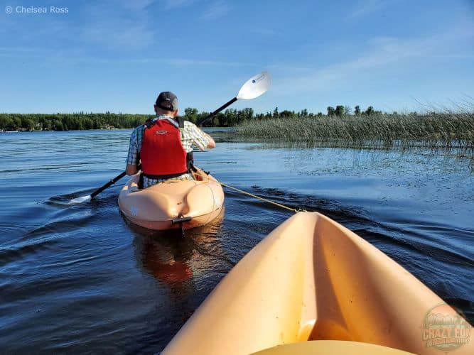 Kris is pulling me with a rope in his kayak back to Lake Isle Kayaking Adventures
