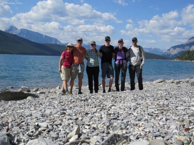 Group shot in front of Lake Minnewanka with mountains behind us while hiking. 