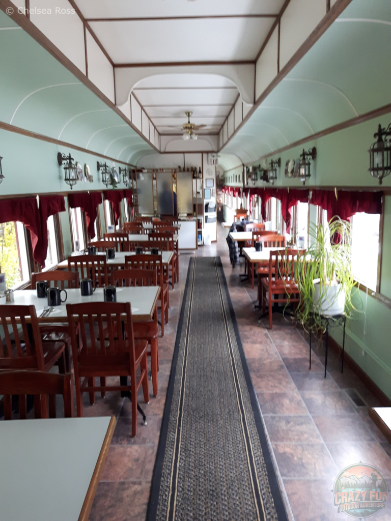 The inside of the train, you can the restaurant has tables on both sides.