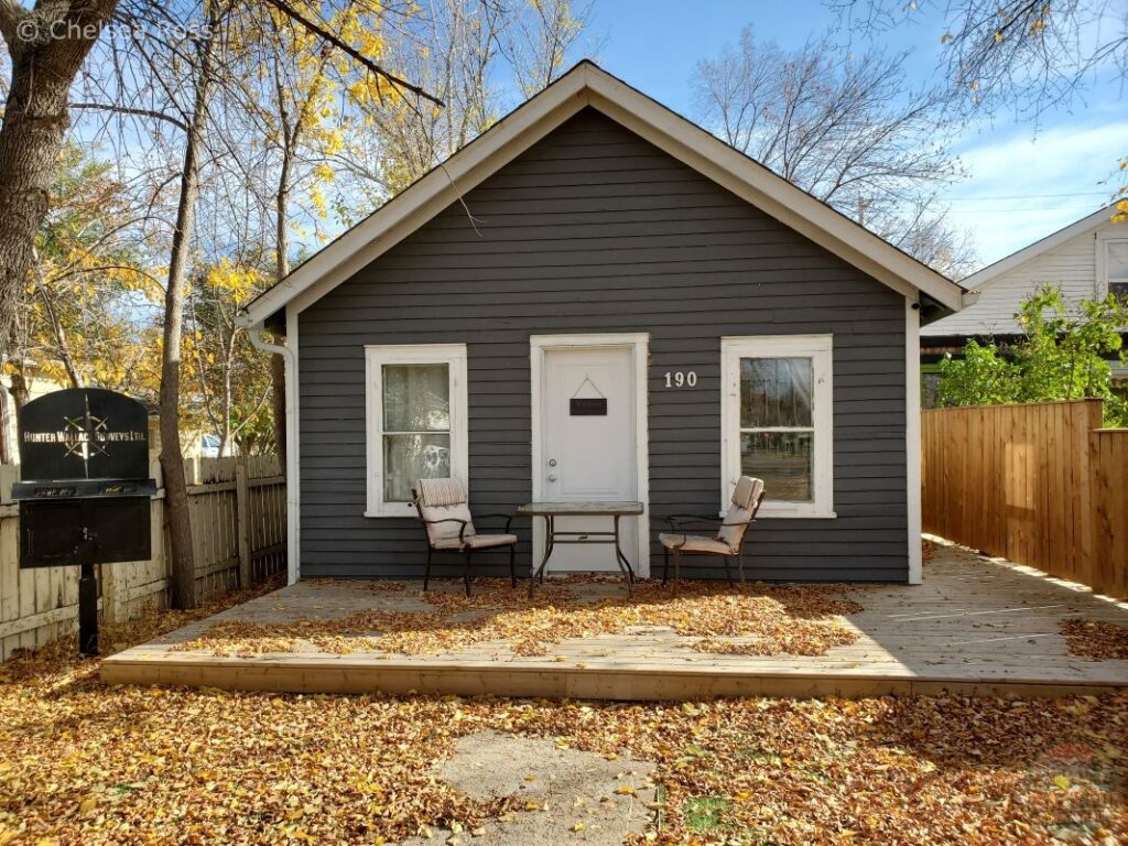 House on a wooden pad with fence on either side. 