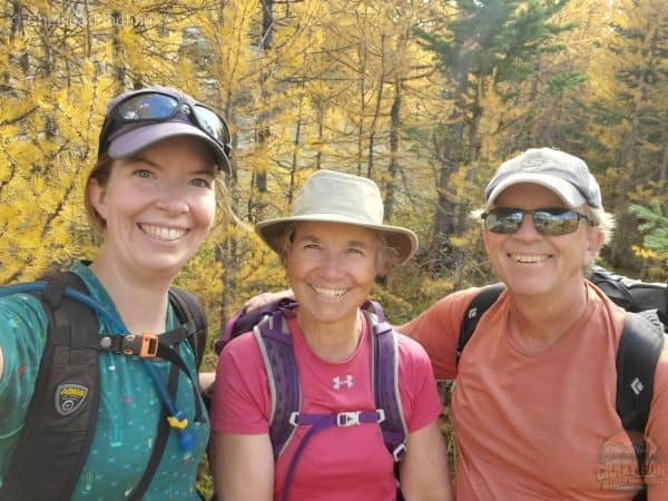 Group selfie with larches behind them.