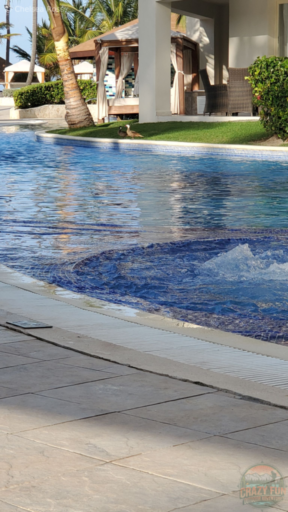 Treat a sunburn by spending some time in cool water. The pool can be seen with rooms with Bali beds in the background.