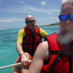 Kris and I taking a selfie while enjoying Majestic resort kayaking. The turquoise rough waves can be seen behind us. The beach is behind us to the right.