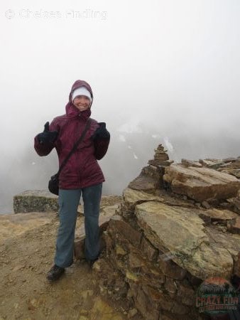 Lady with purple jacket and white toque on at the Fairview Lookout summit as it's starting to snow on Banff Larch hikes. 