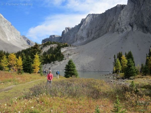 The best larch hikes include Chester Lake that can be seen in the background with a lady wearing a pink shirt.