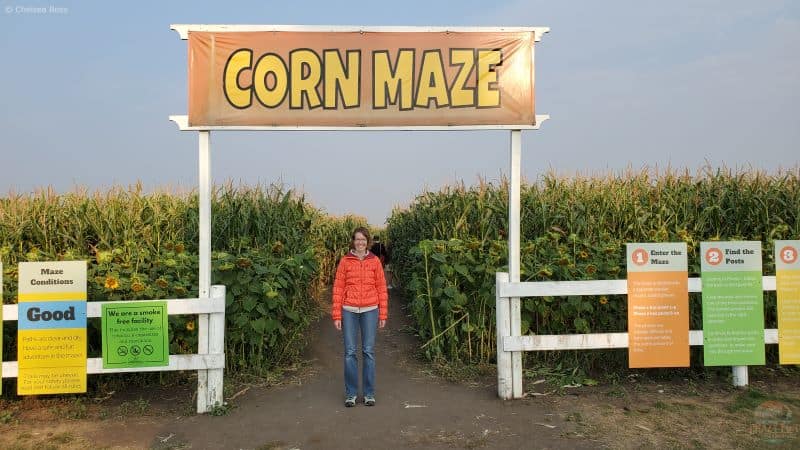 Fall Experiences Near Me include going to the Edmonton Corn Maze. Lady standing under the sign.