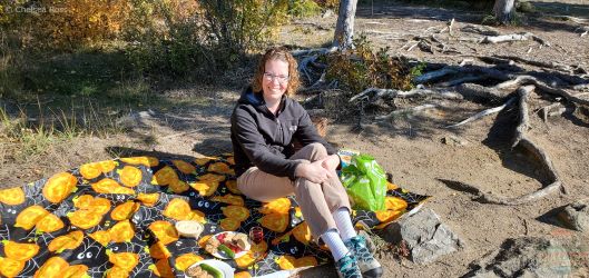 Fall Experiences Near Me shows a lady sitting on a pumpkin placemat for our picnic.