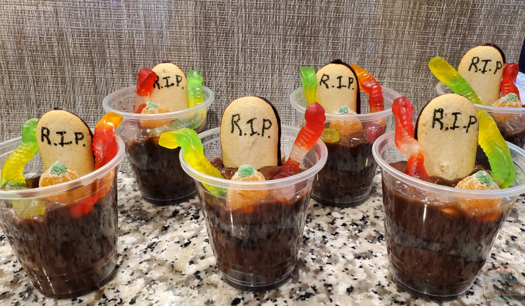 Halloween Party Treats include graveyard pudding cups with Oreo and pudding. 