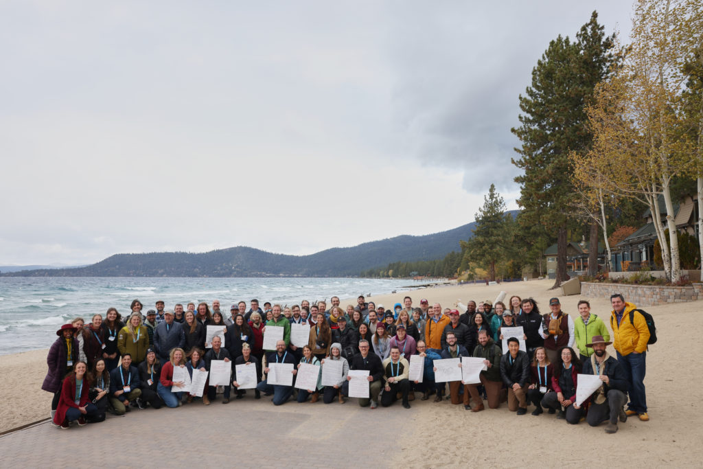 A picture of everyone on the beach at the Outdoor Media Summit.