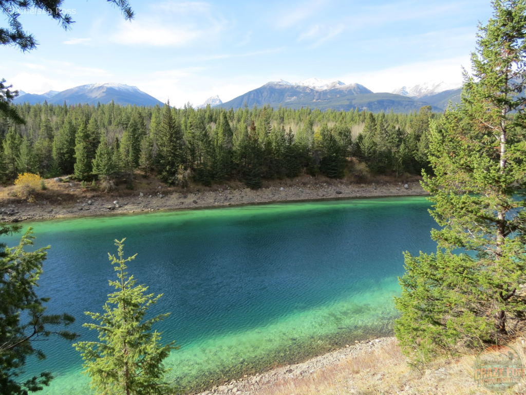 The fourth lake is a long blue-green colour with mountains behind.