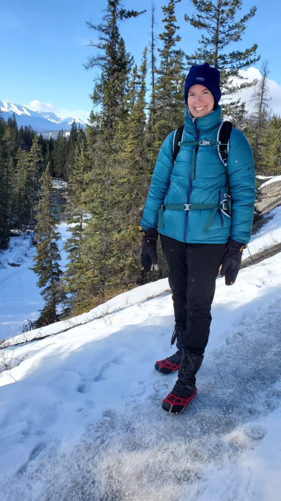 A picture of our tester wearing the Kahtoola Microspikes on the snowy and icy pathway that is part of Maligne Canyon.