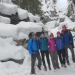 Maligne Canyon Winter Hike shows my family and I in the canyon taking a selfie with snow behind us on rocks.
