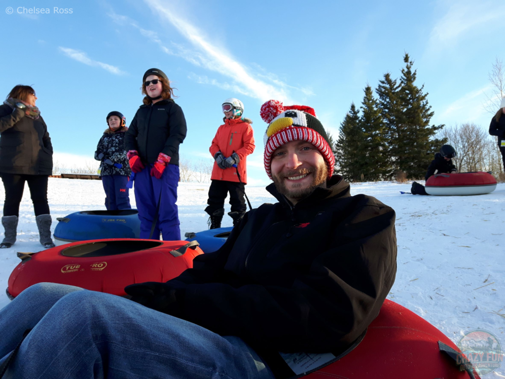 Ways to spend time outdoors: snow tubing. Kris is waiting to be go down on his snow tube.