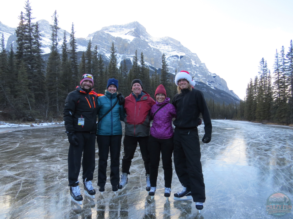 A picture of my family, Kris and I while skating on a lake near Banff with the mountains behind us.