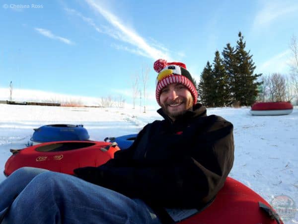 Ways to spend time outdoors: snow tubing. Man waiting to be go down on his snow tube.