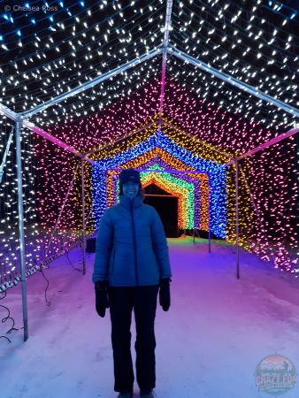 Lady standing under multi-coloured lights.