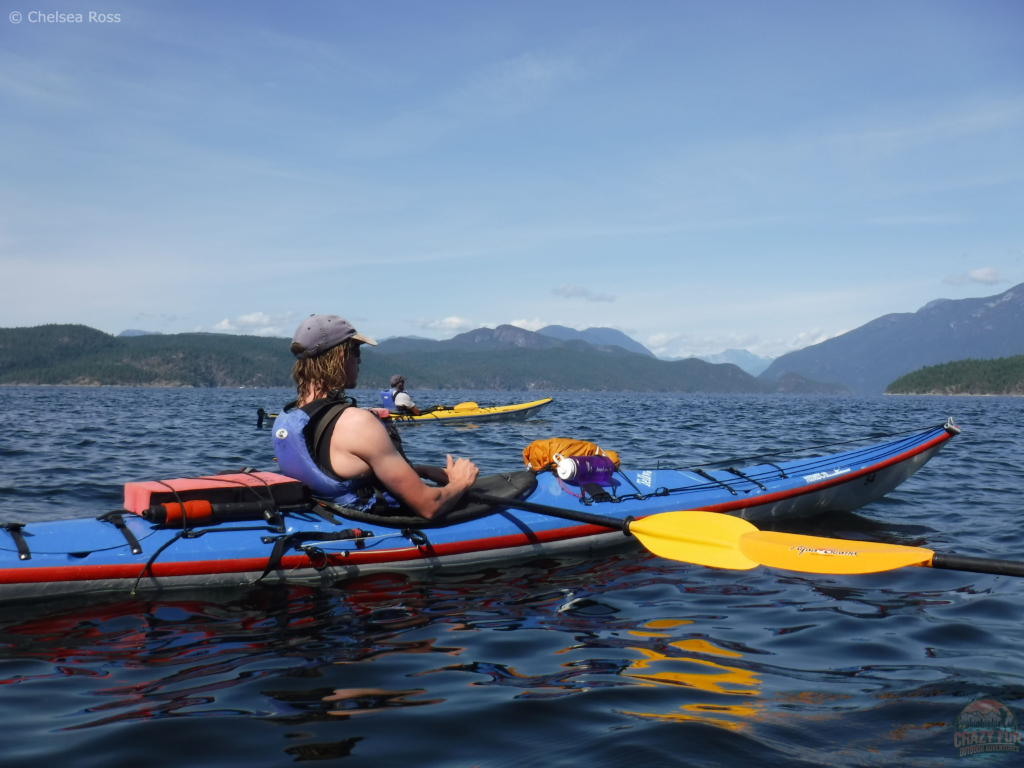 Have an awesome day kayaking with Dad by going on a day trip. Two men are sitting in their kayaks with a beautiful mountain backdrop.