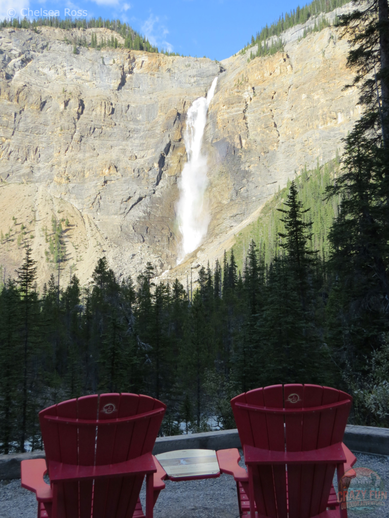 Takakkaw Falls with red chairs in front of it.