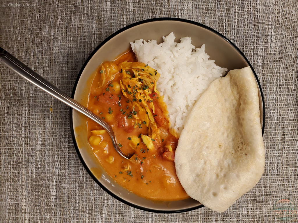Butter Chicken in a bowl with rice and pita.