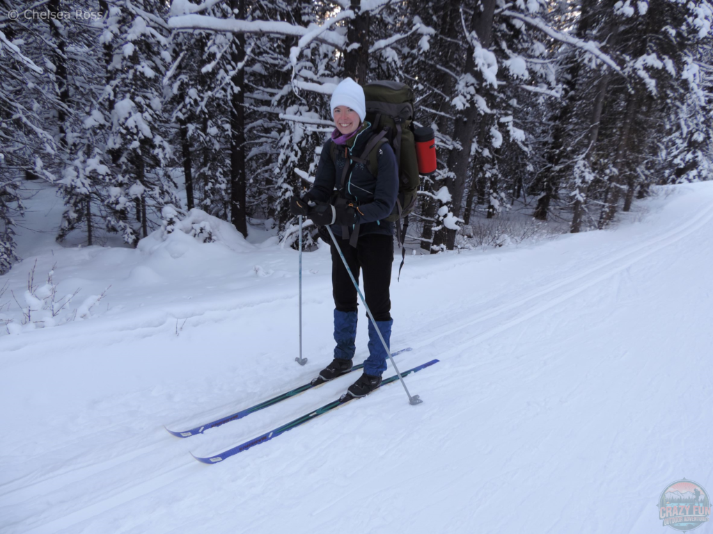 Lady cross-country skiing with a backpack.