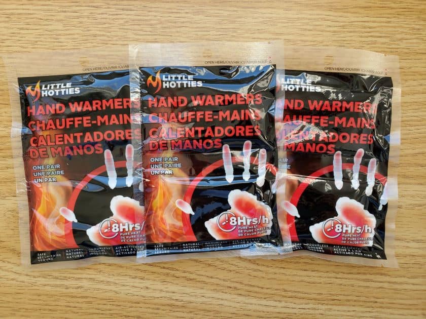 A warm x-country ski includes heat packs for your hands and feet. There are 3 packages side by side with hot hands on them.